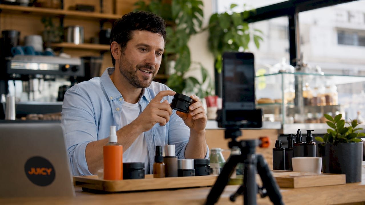 Man filming retail tutorial video in home kitchen