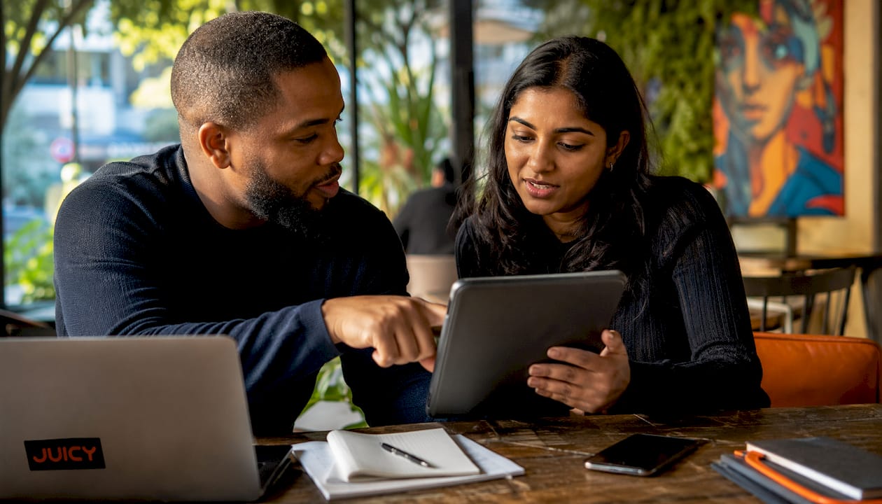 Two colleagues reviewing Meta ad campaigns on tablet